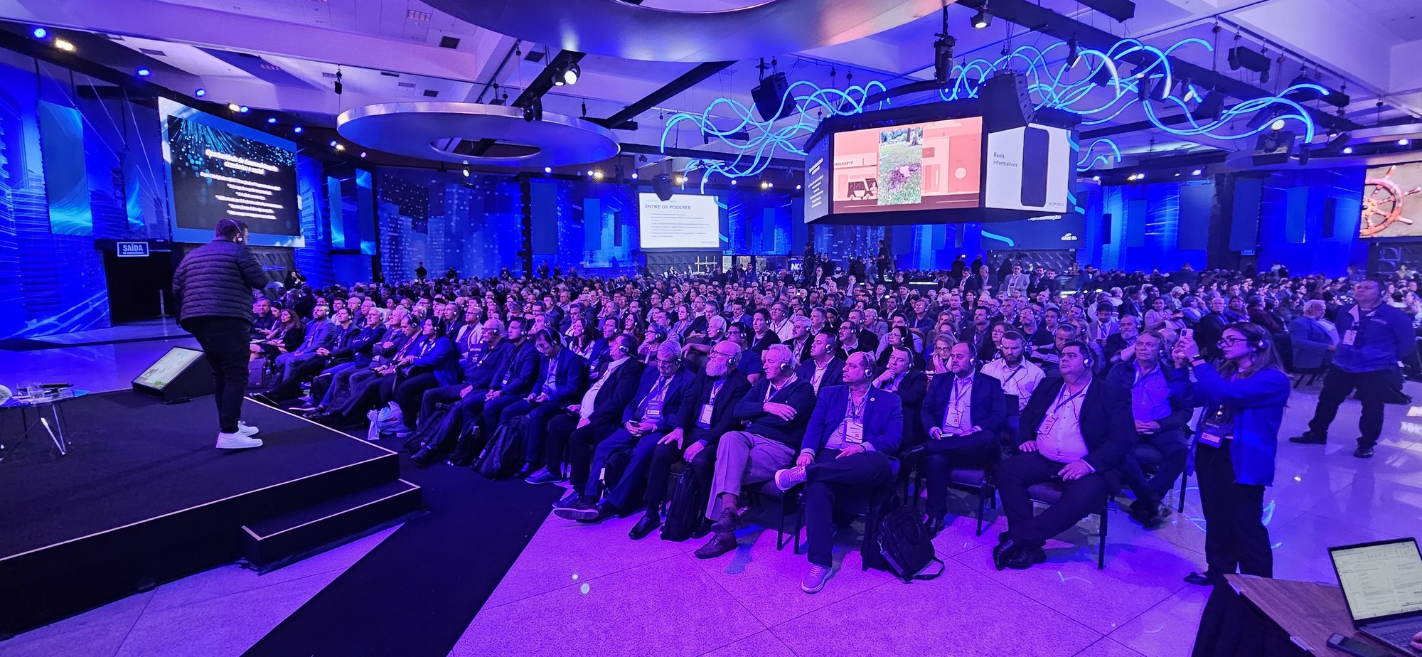 Participantes de evento usando headsets para palestra silenciosa